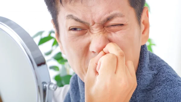 「鼻毛が出ているのが気になって、つい抜いてしまう」「ワックスや脱毛のほうがきれいに処理できるのでは」と考える方は少なくありません。 ですが、鼻毛は見た目の問題だけでなく、鼻の中を守る役割を担っています。自己流で抜く・強く引っ張る・何度も処理すると、鼻の入口に小さな傷ができ、痛みや出血、鼻前庭炎などの炎症につながることがあります。 この記事では、鼻毛を抜くことの危険性、安全な処理方法、受診の目安まで、耳鼻科の視点で詳しく解説します。 POINT 鼻毛を抜くと毛穴に傷がつく 鼻毛カッターでの処理が基本 ワックス脱毛は刺激が強め 鼻毛は不要な毛のように見えても、鼻腔の入口で異物をとらえ、鼻粘膜の防御機能を助ける大切な存在です。見た目を整えたいときほど、抜く・むしる処理ではなく、鼻に負担の少ない切り方を知っておくことが大切です。 鼻毛を抜くとどうなる？ 鼻毛を抜いたあとに起こりやすい症状として、まず多いのが「その場での強い痛み」と「にじむような少量の出血」です。鼻の入口は皮膚と粘膜の境目で非常に敏感なため、1本抜いただけでもジンジンする痛みが出ることがあります。多くは数分から数時間で落ち着きますが、毛穴の部分に傷が残ると、翌日以降もヒリヒリ感や違和感が続きます。 さらに炎症が起こると、鼻の入口が赤くなる、押すと痛い、腫れる、熱っぽい、黄色いかさぶたが付く、ニキビやおできのようなふくらみができるといった症状がみられます。片側だけ強く痛む、鼻をかむたびにしみる、笑ったり触れたりしただけでズキッとする場合は、単なる抜いた直後の刺激ではなく、毛包炎や鼻前庭炎が起きている可能性があります。 悪化すると、膿がたまって白っぽく見える、鼻の穴の入口が狭く感じる、出血とかさぶたを何度も繰り返すといった経過をたどることもあります。数日たっても改善しない場合や、赤みや腫れが鼻先・頬へ広がる場合、発熱を伴う場合は早めの受診が必要です。見た目を整えるための処理が、かえって日常生活に支障の出る痛みにつながることもあるため注意が必要です。 鼻毛を抜くのが危険な理由 鼻毛を抜くのが危険といわれる理由は、単に「痛いから」ではありません。毛を引き抜くと、毛の根元である毛包やその周囲の皮膚に微細な傷ができやすくなります。鼻の入口は、外気にさらされる皮膚の性質と、鼻の中の粘膜の性質が混在するデリケートな部位で、ちょっとした刺激でも炎症が起こりやすい特徴があります。 さらに鼻は、呼吸のたびに空気を取り込み、加温・加湿し、ほこりや微生物、アレルゲンをとらえて除去する重要な防御器官です。鼻粘膜には粘液線毛運動や分泌型IgAなどの防御機構があり、外から入る異物や病原体がそのまま下気道へ届かないように働いています。鼻毛そのものも、この防御の最前線で大きな粒子や異物を受け止める役割を担っています。つまり、鼻毛を過剰に処理することは、見た目以上に鼻のバリア機能へ影響する可能性があります。 特に鼻の疾患を起こしやすいのは、毛抜きで鼻毛を処理する習慣がある方、鼻毛ワックスや強い脱毛を繰り返す方、鼻をほじる癖がある方、鼻を頻繁に強くかむ方です。また、花粉症やアレルギー性鼻炎で鼻の中を触ることが多い方、乾燥しやすい冬場、風邪の前後、糖尿病など感染が長引きやすい背景を持つ方でも悪化しやすくなります。見た目の整え方として「抜く」が習慣化している方ほど、炎症を繰り返しやすいため注意が必要です。 検査/診断の方法 耳鼻科では、まず鼻毛を抜いた時期、痛みや出血が始まったタイミング、処理方法（抜く・ワックス・ハサミ・鼻毛カッターなど）を確認します。そのうえで、鼻の入口に赤み、腫れ、圧痛、かさぶた、膿、できものがあるかを視診で見ます。多くは外来で数分程度の診察で大まかな診断が可能で、強い痛みを伴う大がかりな検査が必要になることはあまりありません。 必要に応じて、鼻鏡や細い内視鏡で鼻の奥まで観察し、炎症が鼻の入口だけに限局しているのか、鼻炎や副鼻腔炎など別の病気が背景にあるのかを確認します。例えば、鼻前庭だけの炎症であれば入口の赤みや痂皮が目立ちますが、鼻汁が多い、粘膜が全体に腫れている、膿性鼻汁が奥から出ている場合には別の病態も考えます。 膿が目立つ場合、何度も再発する場合、治療しても改善しにくい場合には、必要に応じて細菌培養を考慮します。とくに高齢の方や糖尿病のある方、腫れが強い方では、抗菌薬の選択を慎重にする必要があります。多くは診察だけで対応できますが、鼻先や頬まで赤みが広がる、発熱がある、痛みが急に強くなる場合には、蜂窩織炎などの広がる感染も念頭に置いて評価します。 治療の方法・回復期間の目安 治療は症状の強さによって異なります。ごく軽い刺激や小さな傷であれば、まずは鼻を触らない、鼻毛を追加で抜かない、ワックスや脱毛を中止するだけで、2〜3日ほどで痛みが落ち着くことがあります。少量の出血だけで腫れや赤みがほとんどない場合には、この段階で自然軽快することも少なくありません。 一方で、赤み、腫れ、圧痛、かさぶた、できものがある場合には、鼻前庭炎や毛包炎として治療を行います。軽症では抗菌薬の軟膏を塗布し、鼻の中を清潔に保ちながら経過をみます。海外の耳鼻科資料では、軽症の鼻前庭炎に対してムピロシン軟膏を1日2回、14日間使用する方法が紹介されています。中等症以上で腫れや痛みが強い場合、膿がある場合、広がりがある場合には、内服抗菌薬を併用することがあります。 回復期間の目安としては、軽症なら2〜4日ほどで痛みが和らぎ、1週間前後でかなり改善するケースが多いです。軟膏治療を行う場合は1〜2週間程度続けることもあります。膿がたまって大きな腫れになっている場合や、せつのように深い炎症になっている場合は、処置やより強い治療が必要になることがあります。 治療中の処理方法も大切です。鼻毛を整えたい場合は、抜くのではなく、鼻毛カッターや先端が丸い小型のハサミで「見える範囲だけ」を短くするのが基本です。奥まで深く切ろうとしないこと、完全につるつるにしないこと、炎症がある間は処理自体を控えることが重要です。ワックス脱毛や強い脱毛は、一度に複数の毛を引き抜くため刺激が大きく、炎症がある時期には特に避けたほうがよいでしょう。 類似症状の疾患 鼻の入口の痛みやできものは、単なる傷だけでなく、鼻前庭炎、毛包炎、せつ（おでき）、湿疹、接触皮膚炎などでも起こります。花粉症や副鼻腔炎で鼻を強くかみ続けて皮膚が荒れている場合も似た症状になります。赤みが広がる、膿が増える、発熱を伴う場合は、自己判断せず耳鼻科で確認することが大切です。 鼻毛の正しい処理方法 予防で最も大切なのは、鼻毛を無理に抜かないことです。処理をするなら、鼻毛カッターや先端が丸いハサミを使い、鼻の外から見える範囲だけを短く整えましょう。奥まで深く切り込まないこと、頻回に処理しすぎないことも大切です。鼻毛ワックスや強い脱毛は刺激が出やすいため、敏感肌の方や過去に腫れたことがある方は特に注意が必要です。 また、鼻を触る前に手を清潔にする、鼻を強くほじらない、花粉症や鼻炎がある場合は症状をコントロールして鼻をいじる回数を減らすことも予防につながります。乾燥しやすい時期は、室内の湿度を保ち、必要に応じて保湿を意識すると、粘膜の傷を防ぎやすくなります。 さいごに 鼻毛の処理は日常的な身だしなみの一つですが、「抜く」方法は思った以上に鼻への負担が大きいことがあります。痛みや腫れ、出血が続く場合でも、早めに耳鼻科で状態を確認すれば、比較的軽いうちに対処できることが少なくありません。気になる症状があるときは無理に触り続けず、安全な処理方法へ切り替えていきましょう。